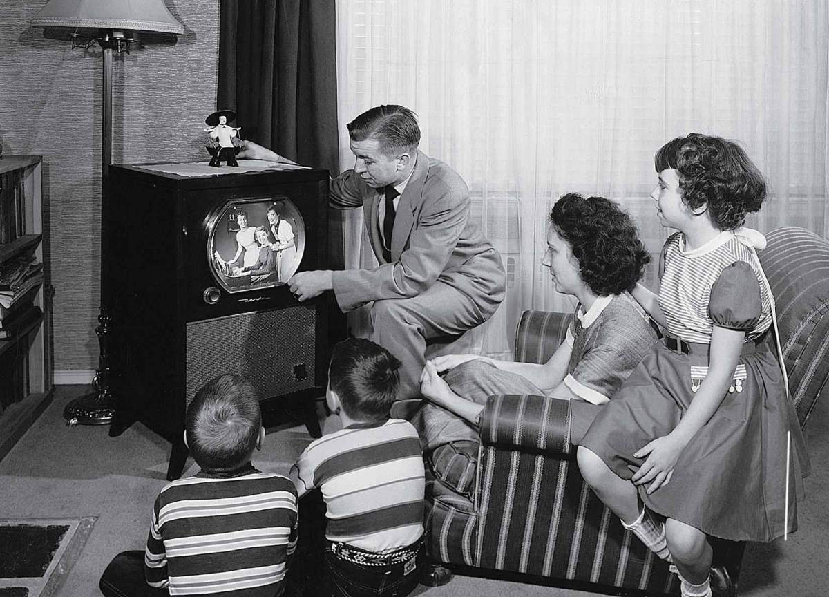 parents-with-three-children-watching-television