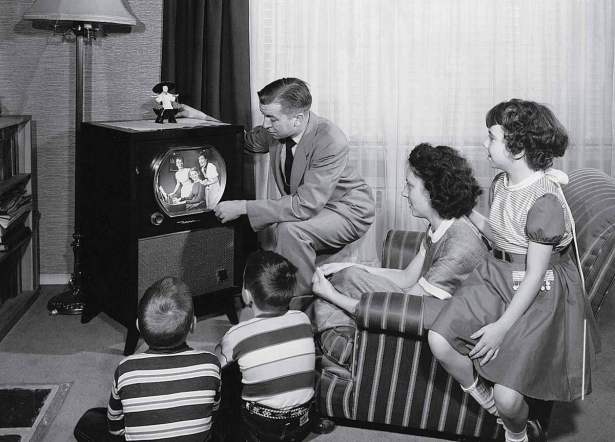 parents-with-three-children-watching-television